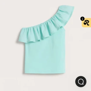 Ljusblå offshoulder topp Kappahl - Snygg ljusblå offshoulder topp från Kappahl i mjuk bomull. Toppen har en volang längs den asymmetriska halsringningen och är ärmlös på ena sidan. Bara använd 2ggr och inga defekter🩷 läs gärna bio❤️