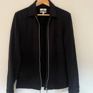 Svart zip/overshirt - Säljer nu denna svarta overshirt/zipen ifrån cos. Man kan ha den både stängd eller öppen (som jag har på bilden). Jackan är väldigt lätt att styla och man kan ha den i princip året om. Säljer pga att jag tyvärr växt ur den. Nypris 1300