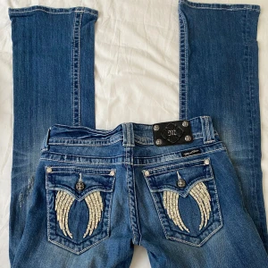 Miss Me jeans  - Snygga bootcut jeans från Miss Me med coola broderade vingar i silver på bakfickorna. Storlek 28 men  små i storlek. Midjemått 36 cm innerbenslängd 84 cm 💓