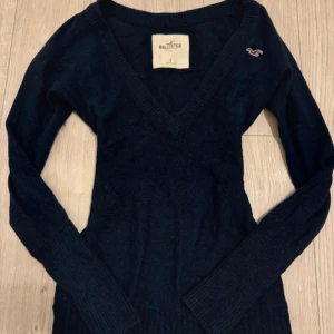 Tröja från Hollister - Mörkblå stickad tröja från Hollister med v-ringning och långa ärmar. Storlek S men lite stor i storleken. Inga märkbara defekter💞