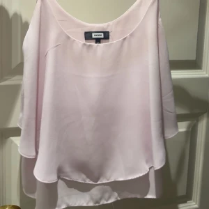 Ljusrosa blus med lager från Bik Bok - Supersöt ljusrosa blus från Bik Bok i flowy, dubbellager design. Blusen har vid passform och ärmlös stil med rund halsringning. Perfekt för dig som gillar en luftig och feminin look.