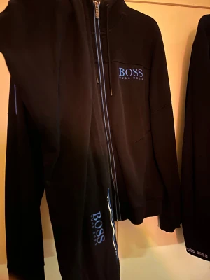 Svart hoodie från Hugo Boss med blå logga - Gammal dress boss sönder därför lågt pris storlek M 