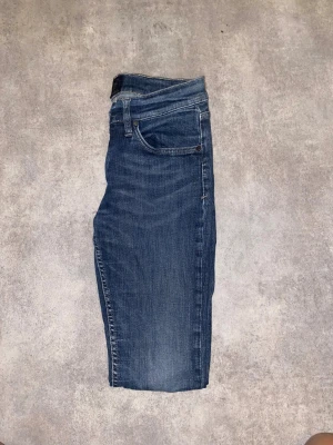 Blåa jeans från tiger of Sweden storlek 30/32 - Snygga blå jeansbyxor från tiger of Sweden , modell slender. Perfekta för dig som gillar stilrena och bekväma jeans.