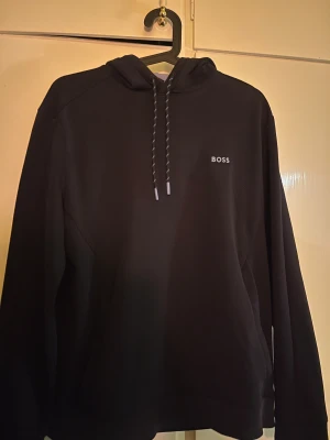 hoodie från BOSS  - Marinblå  hoodie från BOSS med baby blå detaljer luva och vid armarna. Som ny skick då inte använd darför säljer jag också sällsynt modell nypris 2199kr 