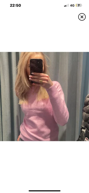 Ljusrosa stickad tröja - Superfin ljusrosa stickad tröja med rund hals och långa ärmar. Tröjan har ribbade muddar vid ärmslut och nederkant, vilket ger en snygg och enkel look. Perfekt att matcha med jeans eller kjol för en chill stil.