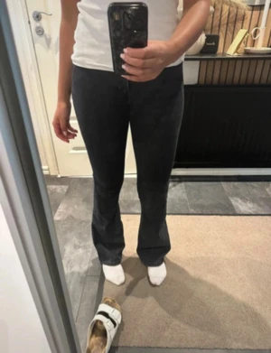 Svarta bootcut jeans från Gina Tricot - Snygga svarta jeans från Gina Tricot med bootcut passform och klassisk femficksdesign. Jeansen har låg midja och är tillverkade i stretchigt denim som sitter bekvämt. Perfekta för dig som gillar en trendig siluett med lite utsvängda ben.