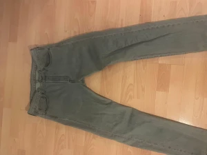 Levi's 501 grå jeans straight fit - Säljer ett par klassiska Levi's 501 jeans i grått med straight fit. Jeansen har fem fickor, knappgylf och den ikoniska Levi's-lappen bak i midjan. Perfekt för dig som gillar tidlös stil och vill ha ett par jeans som funkar till allt. W32 L32