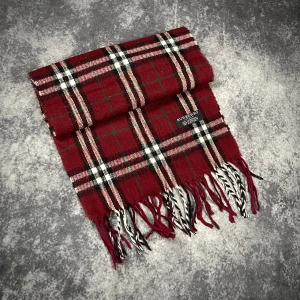 Rutig vinröd halsduk från Burberry - Snygg rutig halsduk från Burberry i vinrött, svart, vitt och grönt. Gjord av 100% lammull och tillverkad i England. Klassisk design med fransar i ändarna och tydlig Burberry-label. Perfekt för att lyfta din vinterstil.