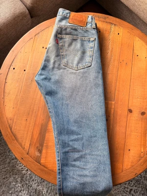 Levi's 501 ljusblå jeans straight fit - Klassiska Levi's 501 jeans i ljusblå tvätt med raka ben och normal passform. Egna gjorda slitningar fram. Storlek W30 L28. Hör av dig vid frågor och funderingar! Mvh