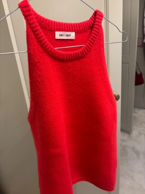 Soft Goat Topp - Snygg röd kashmir topp med ribbad halsringning och ärmlös design. Materialet är mjukt och bekvämt, och toppen har en super snygg, cool färg. Bara använts ett fåtal gånger!!