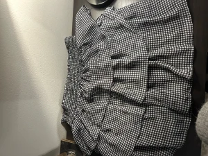 Rutig volangkjol från H&M Divided - Supersöt svartvit rutig kortkjol från H&M Divided med volanger och smock i midjan. Kjolen har en luftig känsla och är perfekt för dig som gillar en lekfull och trendig stil. Tillverkad i mjukt material som känns skönt mot huden.