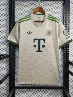 2025/2026 Bayern Oktoberfest Special Edition Light Grey - Snygg FC Bayern München fotbollströja från Adidas i elegant ljus design med gröna detaljer. Tröjan har klassiska Adidas-ränder på axlarna, klubbmärke på bröstet och T-Mobile logga framtill. Rund hals och korta ärmar, tillverkad i lätt och ventilerande material för hög komfort. Perfekt för dig som vill stötta Bayern München med stil, både på planen och till vardags.