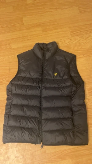 Svart dunväst från Lyle & Scott - Använd 2ggr, nyskick, inköpt för en månad sen kvittot finns på mail. Storlek L, nypris 1300kr