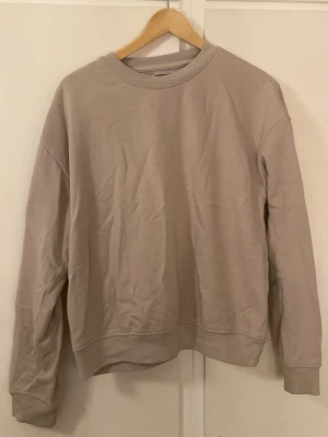 Beige sweatshirt från 157, storlek S - Säljer en enkel och stilren beige sweatshirt från 157 i storlek S. Tröjan har rund hals, ribbade muddar vid ärmslut och nederkant samt långärmad passform. Perfekt för chill dagar och passar till allt. Mjuk insida i bomullsmix.