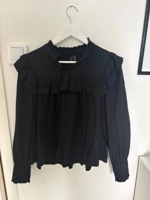 blus med volang - fin blus med volanger och knytning i halsen. använd något men i fint skick