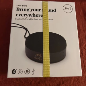 JAYS s-Go Mini - JAYS s-Go Mini är en portabel Bluetooth-högtalare med 12 timmars batteritid, vattentålig och dammsäker design. Den är liten, lätt att ta med och kan länkas med en annan högtalare för stereoljud. Levereras med skyddspåse och laddningskabel. Produkten är ny i förpackning.