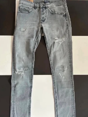 Dondup jeans - Snygga grå jeans med skinny passform och slitna detaljer på både fram- och baksidan. Det är ett par Dondup jeans.