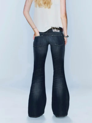 Bootcut jeans i mörkblå denim - Snygga bootcut jeans från Only i mörkblå tvättad denim med klassiska fem fickor och låg midja. Jeansen har markerade slitningar framtill och breda ben som ger en cool retrovibe. Perfekta för dig som gillar statement-plagg och vill sticka ut.