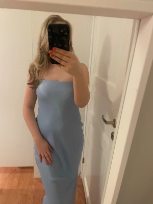 Ljusblå axelbandslös långklänning - Jättefin ljusblå tubklänning i silkeslikt material. Jag är 165 och klänningen går ner till anklarna på mig, priset går att diskutera! 💘