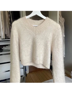 Mohair stickad tröja❤️ - Supermjuk och fluffig beige stickad tröja med croppad passform och v-ringad hals. Tröjan har långa ärmar och bred ribbstickad mudd vid halsen, ärmslut och nederkant. Perfekt för lager-på-lager och chill outfits.