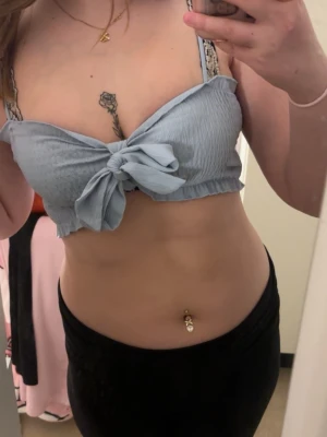 Ljusblå croppad linnetopp med knyt - Superfin ljusblå croppad linnetopp med en söt knytdetalj framtill. Du kan själv välja om du vilk knyta eller ej.