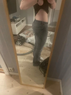 Grå raka jeansbyxor - Säljer ett par grå jeansbyxor boutcut. Jeansen har en snygg tvättad look och normal passform men väldigt stretchiga. Vet däremot ej riktigt storlek få lappen lyssnar men skulle säga wide 28 lenght 32. Jag har oftast s eller m och de passar mig bra