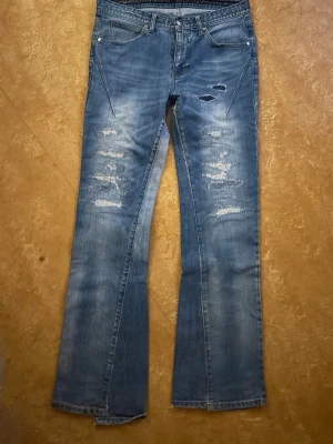 Number nine denim (n)ine  - A good pair of authentic number (n)ine jeans from the early 2000s. These jeans are in collaboration with (NANO-UNIVERSE) Tokyo. They are made in Japan and the denim fabric that’s used is also made in Japan, so the construction, quality and feel of the pants are really good. They have the classic music notes going around the waist and on the pockets. The distressing is factory made from number nine, with denim backing. They fit slim with a nice bootcut/flare. They have the hedi boy swag for sure.