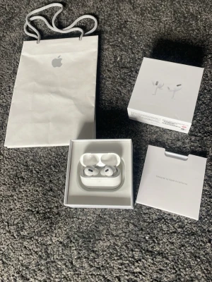 Apple AirPods Pro med laddningsetu - Säljer ett par vita Apple AirPods Pro med trådlöst laddningsetui. Hörlurarna har en stilren och kompakt design i plast och levereras i originalförpackning med tillbehör. Perfekta för dig som vill ha brusreducering och grymt ljud i vardagen.
