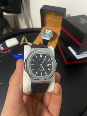 Svart herrklocka från Bbonnel - Stilren herrklocka från Bbonnel med svart urtavla, datumvisning och silverfärgade markeringar. Boetten är i rostfritt stål med en åttakantig form och svart armband i silikon. Perfekt accessoar för dig som gillar en modern och clean look.