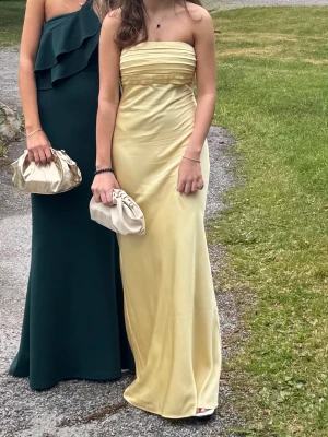 Ljusgul balklänning - Balklänning från Abercrombie & Fitch. Storlek XSP (Petite längd). Så fin gul färg. Det är klister/gummi högst upp i bysten som hjälper till att hålla klänningen uppe. Små skavanker längst ner bak, se sista bild. Men inte så grova så man tänker på det. Ca 120cm lång. Ca 40cm tvärsöver högst upp. Blir lite bredare längre ner ca 1-3cm. Använd en gång. Pris kan diskuteras!!!!💐😜