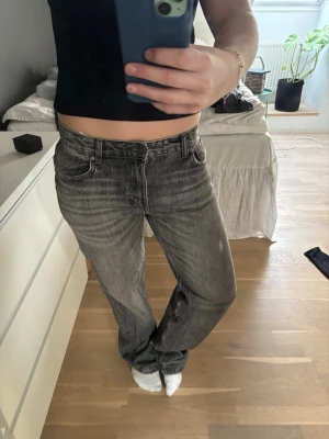 Grå loose fit jeans med tvättad look - Säljer ett par grå baggy  jeans.