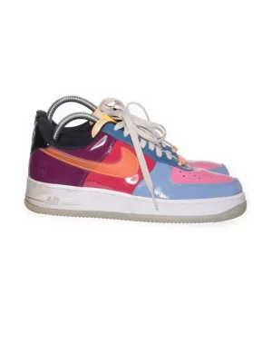 Nike Air Force 1 ”Undefeated” - Färgstarka Nike Air Force 1 sneakers med glansig finish. Skorna har en mix av blått, rosa, orange och lila med vit sula och svarta detaljer. Klassisk låg modell med vita skosnören och tydlig Swoosh-logga på sidan. Perfekta för dig som vill sticka ut.