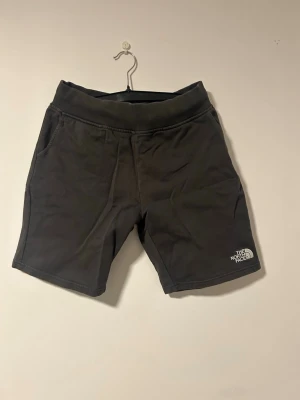 Mörkgrå shorts från The North Face - Mörkgråa mjukisshorts från The North Face med ribbad midja och två sidofickor. Shortsen är knappt använda då de varit  försmå nästan sedan jag köpt de. Pris kan diskuteras. Fler bilder kan skickas vid behov.