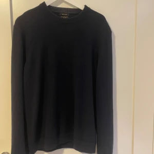 Mörkblå merinoulltröja Massimo Dutti - Snygg mörkblå stickad tröja från Massimo Dutti i extra fin merinoull. Klassisk rund hals och långärmad modell med ribbade muddar vid halsen. Perfekt för dig som gillar stilrena och enkla plagg med premiumkänsla. Knappt använd. Hör av er vid frågor 