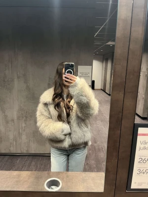 Beige fluffig pälsjacka - Säljer en supermjuk och fluffig beige pälsjacka med bred krage och långa ärmar. Jackan har en oversized passform och är perfekt för kalla vinterdagar. Stängs framtill och har en lyxig känsla som lyfter vilken outfit som helst.