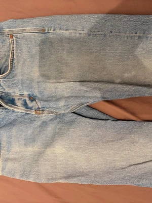 Ljusblå neuw jeans - Säljer ett par klassiska ljusblå jeans från neuw. Jeansen har fem fickor, gylf med dragkedja och knapp samt kontrastsömmar. Perfekta till en avslappnad och trendig look. Materialet är 100% bomull för en skön vintagekänsla.
