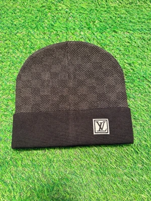 Svart Louise Vuitton mössa med rutmönster - Snygg svart mössa från Louise vuitton med diskret rutmönster och vikt kant. På kanten sitter en broderad L.V-logga i vitt. Perfekt accessoar för dig som gillar exklusiv streetstyle och vill sticka ut med en klassisk designerlook.