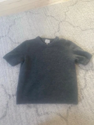 Grå stickad tröja HM - Säljer denna fina stickade kortärmad tröja från HM. Använd några gånger och köptes för 1 månad sen🥰