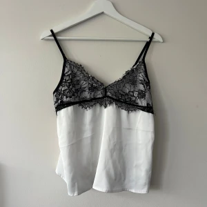 Vitt spetslinne - Säljer detta vita ”satin” linnet med svarta spetsdetaljer som är använd 1 gång 🖤 obs! Köp innan 2/10 för sen reser jag bort. 