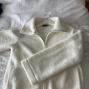 Vit teddyjacka (Lager 157) - Mysig vit teddyjacka från 157. Boxig modell som slutar precis innan höften på mig som är 160. 