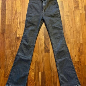 Bootcut jeans från Zara, svarta - Svarta bootcut jeans från Zara i klassisk denim. Byxorna har hög midja och raka ben som blir bredare nedtill för en snygg siluett. Tillverkade i jeansmaterial och perfekta för dig som gillar en retroinspirerad look.