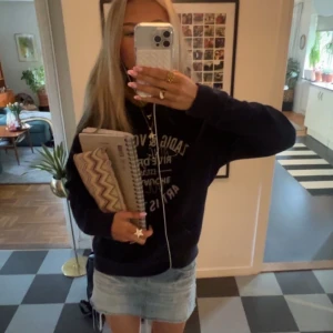 Marinblå hoodie Zadig & Voltaire - Snygg mörkblå hoodie från Zadig & Voltaire med tryck i vitt och paljettdetaljer framtill. Tröjan har huva, magficka och långa ärmar. Perfekt för dig som vill ha en cool look. Gott skick, storlek M. Liten i storleken. 