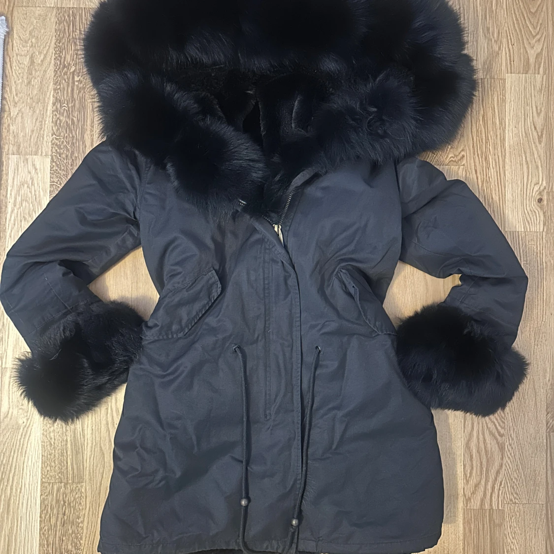 Svart parkas med pälsdetaljer