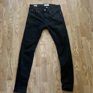 Svarta skinny jeans från Calvin Klein - Svarta skinny jeans från Calvin Klein Jeans med klassisk femficksdesign och snygg CK-logga bak i midjan. Jeansen är i stretchigt bomullsmaterial och har smal passform hela vägen ner. Perfekta för dig som gillar en stilren och tajt look.