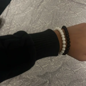 Svart och vitt pärlarmband - Två stilrena armband med runda pärlor, ett i svart och ett i vitt. De är elastiska och passar de flesta handleder. Perfekt accessoar för att ge din outfit en enkel men snygg touch. 2 för 60kr