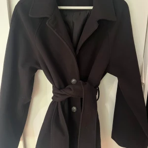 Gina tricot kappa - Kort svart kappa med knappar och bälte från gina tricot. Storlek S, bra skick