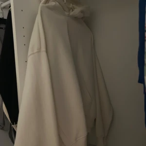 Oversized beige hoodie med huva - Säljer en oversized beige hoodie med huva och snörning. Tröjan har en klassisk känguruficka framtill och långa ärmar. Perfekt för dig som gillar en chill och avslappnad stil.