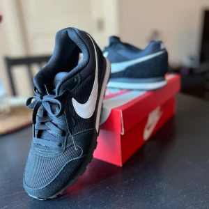 Svarta Nike sneakers med vit swoosh - Säljer ett par svarta Nike sneakers med vit swoosh på sidorna. #nike