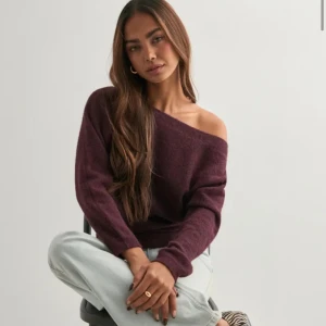 Vinröd offshoulder stickad tröja - Mysig vinröd stickad tröja med offshoulder-design och lång ärm. Tröjan har en loose passform och är perfekt för dig som gillar en avslappnad men ändå trendig stil. Tröjan är använd en gång, säljer för att jag har många liknande redan! 🥰