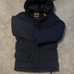  Parajumpers vinterjacka - Säljer en mörkblå Parajumpers Anchorage dunjacka med huva och flera praktiska fickor. Jackan har klassisk patch på ärmen och quiltad insida. Perfekt för kalla dagar och riktigt snygg streetstil.priset kan diskuteras😊